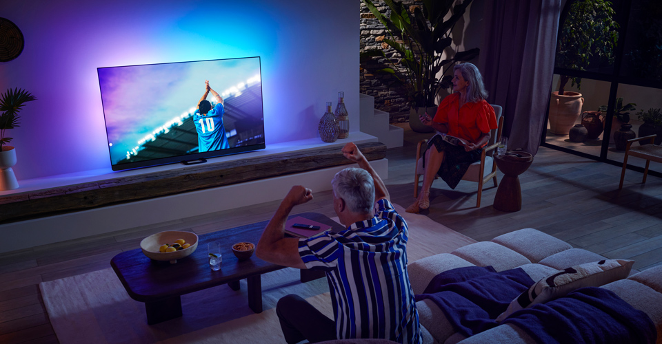 Ģimene skatās maču ar OLED TV