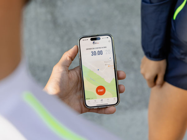 Skrējiena dalībnieks pārbauda savu tālruni, lai uzzinātu, kad sāksies skrējiens.