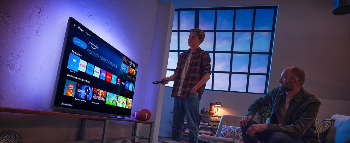 Vīrietis izvēlas lietotni Philips viedtelevizorā